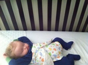 Baby Nathaniel Sleeping in Crib in Tucker Sling