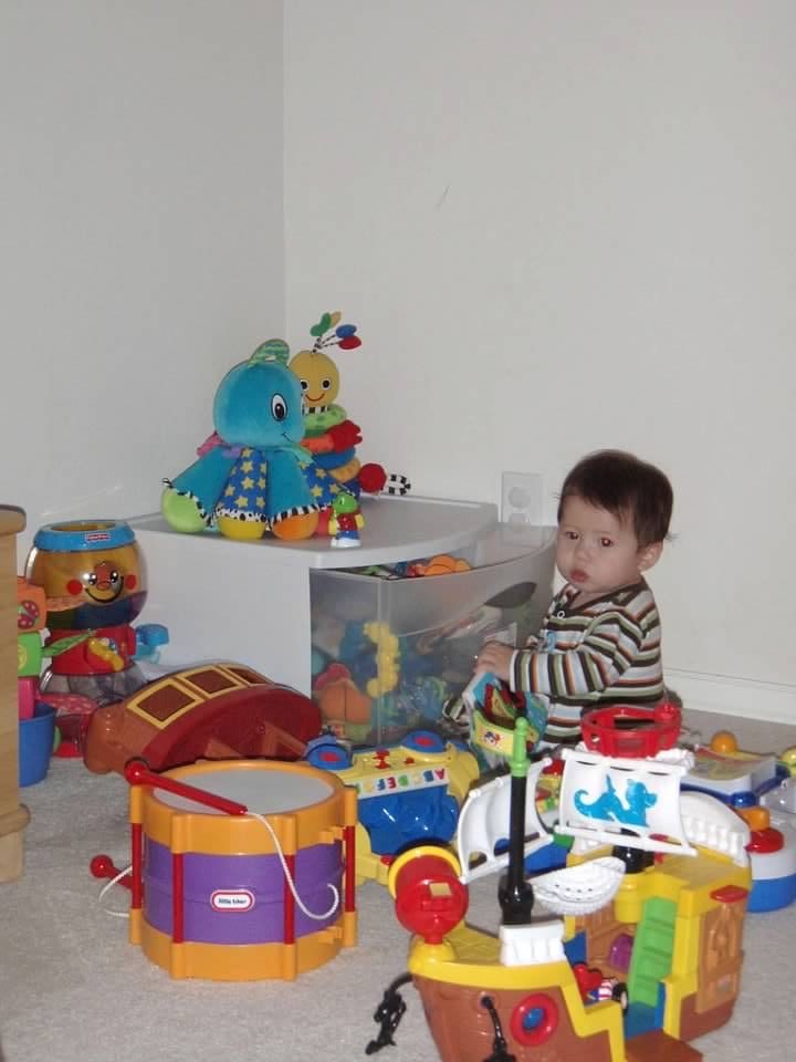 child surrounded by toys 