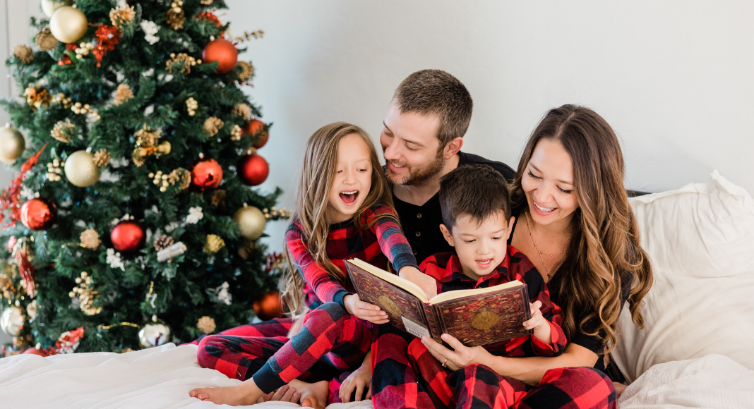 Family celebrating Christmas in New Orleans reading books by tree