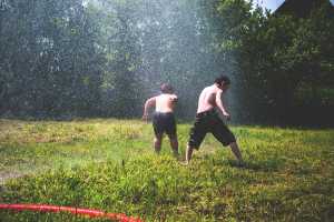 Kids playing in a sprinkler.