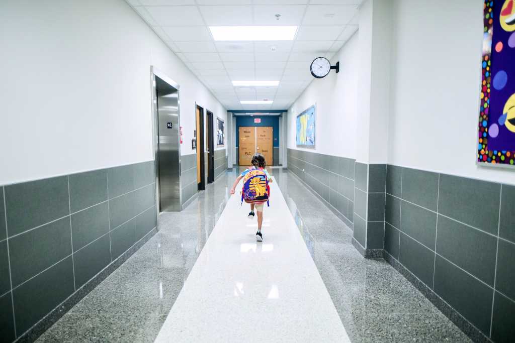Child running down the school hallway.