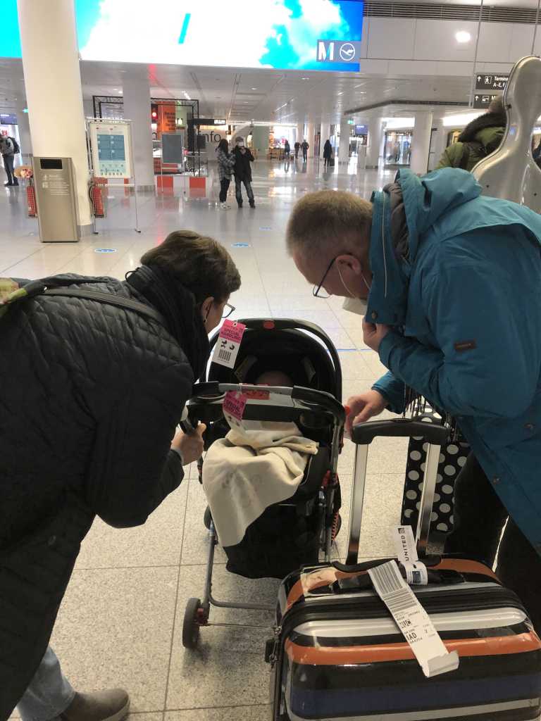Grandparents admiring their grandchild at the airport.