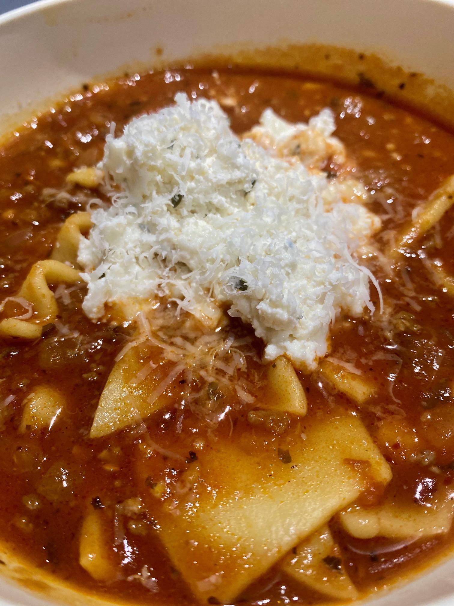 Easy slow cooker lasagna soup topped with cheese.