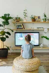 Young child sits and watches TV
