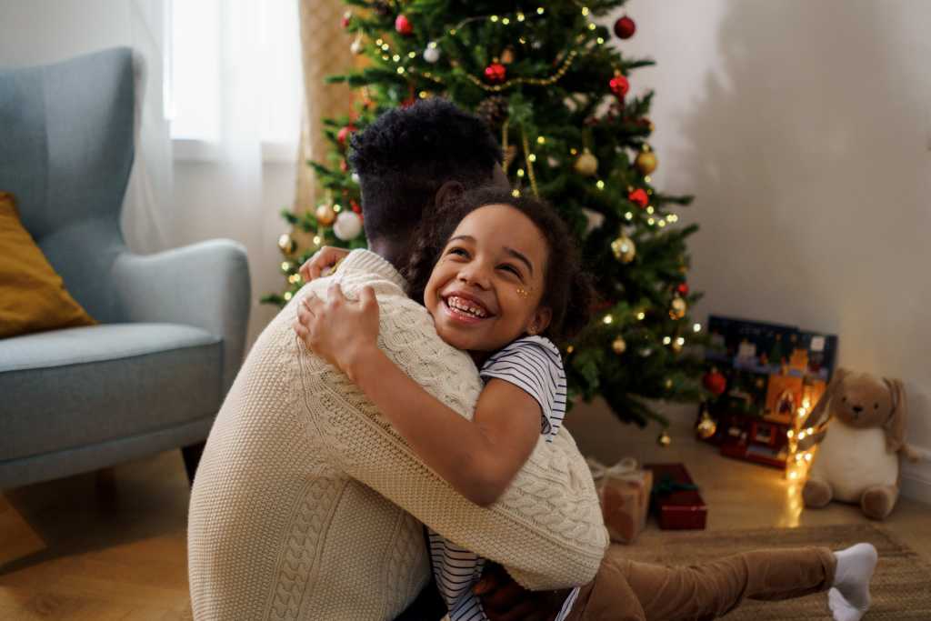 Mother and son hugging in front of the Christmas tree