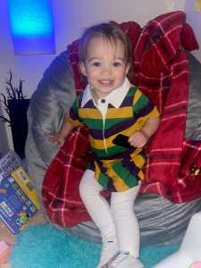 Little girl in Mardi Gras striped dress.