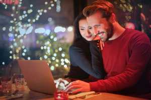 Husband and Wife smiling at the computer together