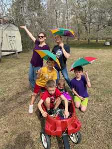 Impromptu parades to decorate with beads are always fun! Kids in a wagon with Mardi Gras umbrellas.